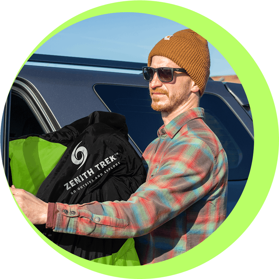 A man holding onto some bags in front of a car